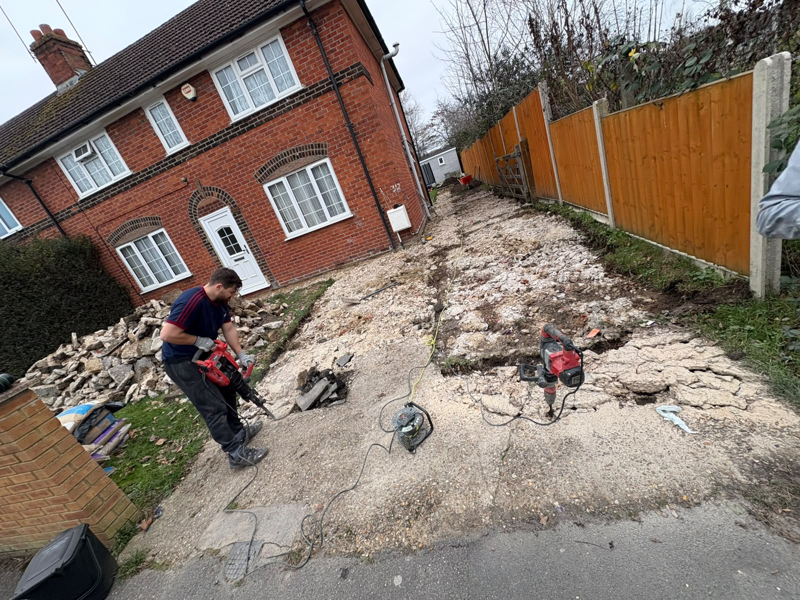 Old concrete driveway being broken out with an SDS breaker before rebuild